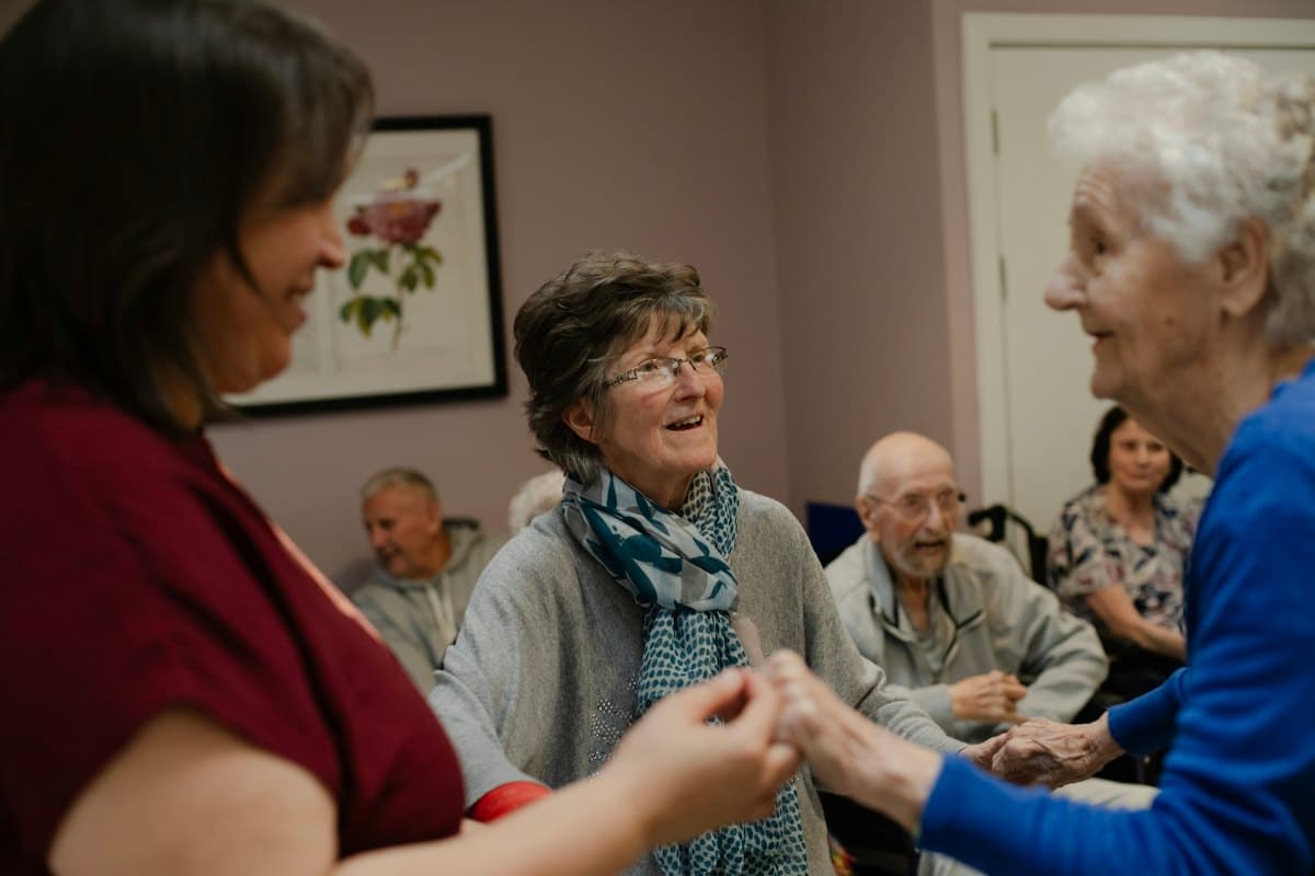 Older people laughing and holding hands at a social get-together